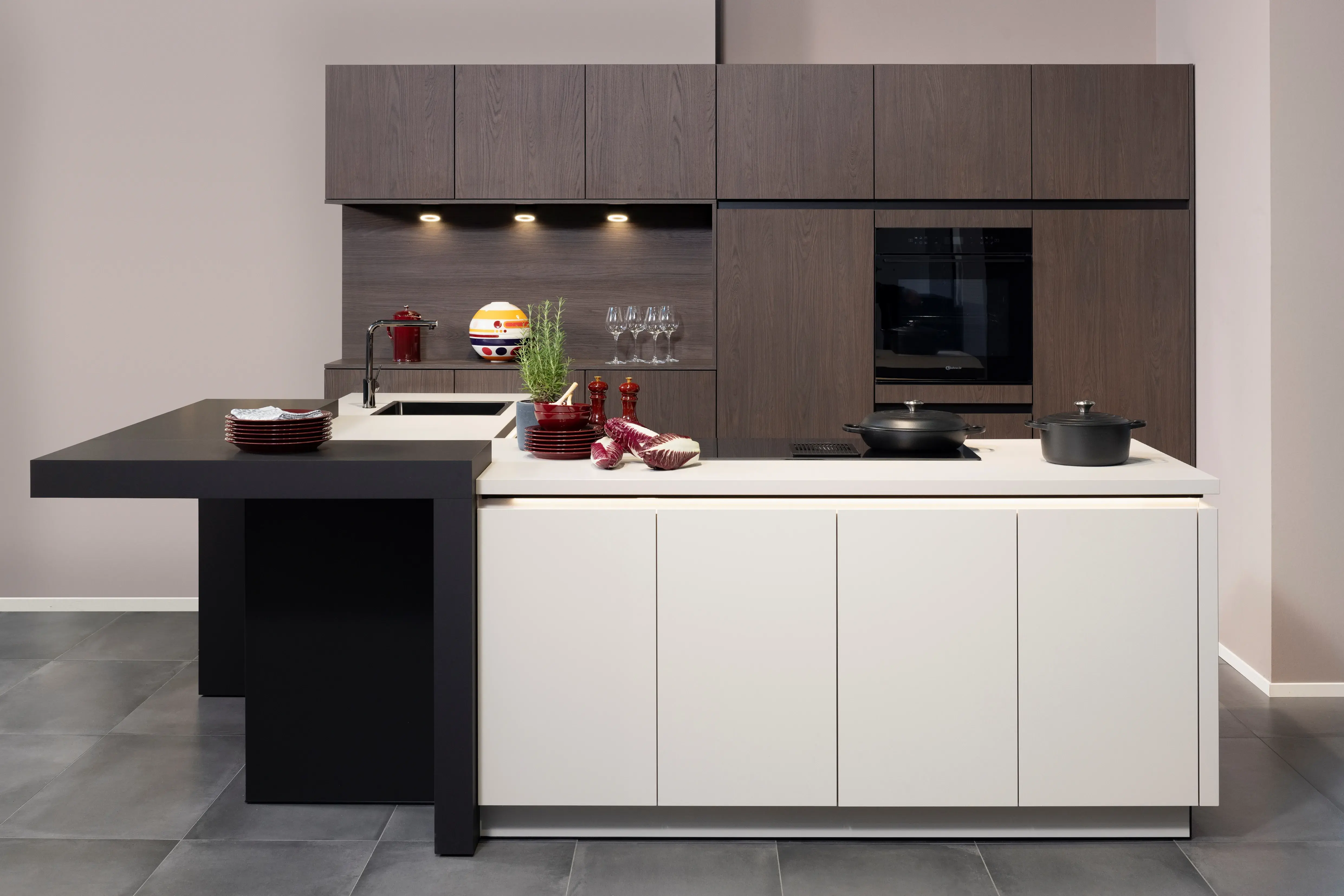 APL:Kashmir und Schwarz Front: Feel Kashmir Front: Casella Dark Oat Korpus: Graphit  Griff: Grifflos Kashmir Geräte: Bauknecht Armatur: Ukinox Spüle: Ukinox  Features: Seitenschränke mit 152 cm Fronthöhe, Kühlschrankumbau für 140 cm Nische, Griffleistenbeleuchtung,  Thekenlösung, Downlights in Regalnische, Spüle in Titaniumoptik